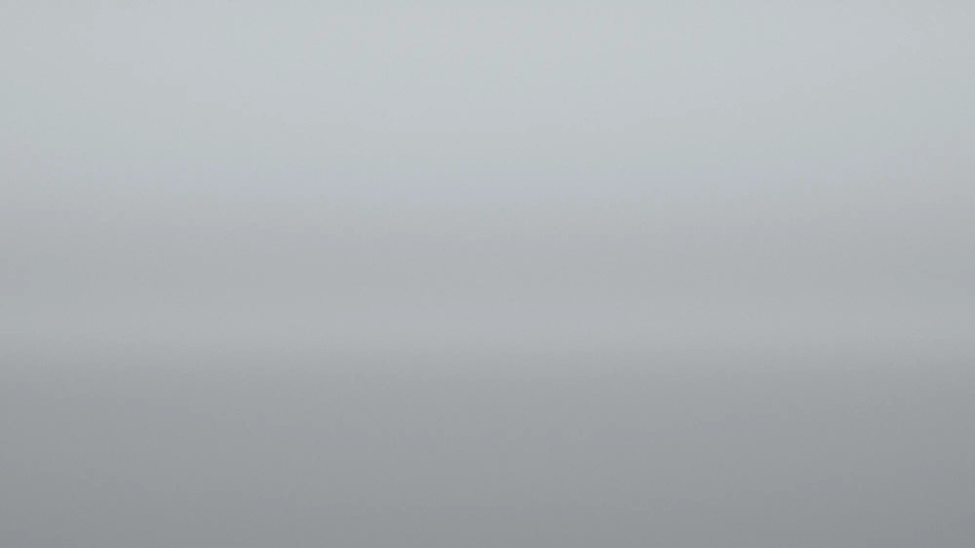 A low wall of grey fog sits over flat water, the horizon almost dissolved.